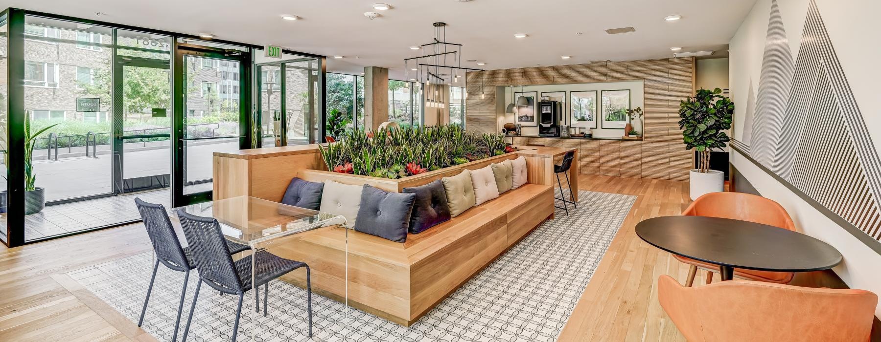 a living room with a large glass wall and a large wood floor